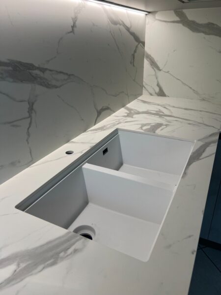 Lavello integrato sottotop in cucina moderna con schienale effetto marmo