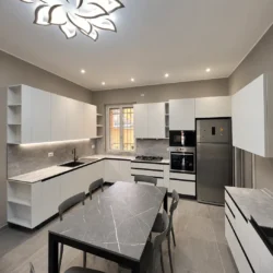 Cucina moderna su misura a Desio con ante chiare, gole nere e piano grigio